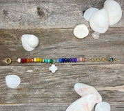 Hand-knotted rainbow gemstone bead bracelet in yellow gold with extender and charms