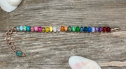 Hand-knotted rainbow bead bracelet in rose gold with extender and charm
